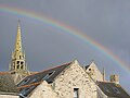 Le clocher de l'église Saint-Arzel devant un arc-en-ciel.