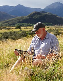 Wikipedian sitting in the grass with a laptop