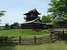 Tour de garde à deux étages et toit en pente entourée d'un enclos et d'autres bâtiments.