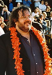 portly white man wearing a black shirt and orange garland