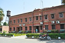 Old Engineering Building of the institute, an antiquated water tank can be seen in the background AAI, Allahabad.jpg