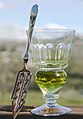 Image 6A reservoir glass filled with a naturally colored verte absinthe, next to an absinthe spoon (from List of alcoholic drinks)