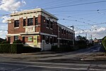 A photo of the main entrance for Glenhuntly tram depot. There is double track up the right hand side, leading to the sheds in the back.