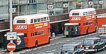 Routemasters with orange and white livery towing luggage trailers outside Heathrow Terminal 2, August 1972 BEA Routemasters, Heathrow Airport, 13 August 1972 (2).jpg