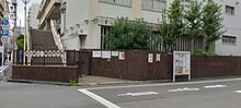 東京都立一橋高等学校の通信制課程生徒用昇降口の反対側から撮影。開庁前であるため昇降口の門は閉鎖している。なお、開庁直後と同じ位置である。