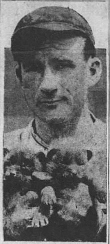 Alabama Pitts in a baseball uniform holding two cub team mascots.