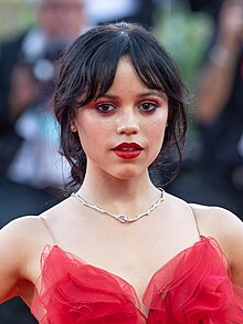 Jenna Ortega posing in a red outfit at the 81st Venice Film Festival