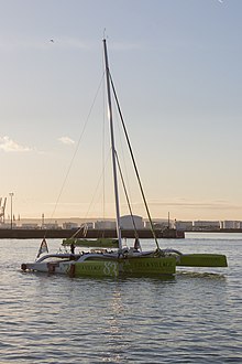 Le trimaran quitte le port alors que le soleil se lève