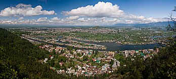 Vista panorâmica de Serinagar, a capital de verão e maior cidade de Jamu e Caxemira, na Índia. A cidade é conhecida pelo seu ambiente natural, vários jardins, orlas fluviais e casas flutuantes. Também é conhecida pelo artesanato tradicional da Caxemira, como o xale da Caxemira (feito de pashmina e lã da caxemira), papel machê, escultura em madeira, tecelagem de tapetes e fabricação de joias, bem como pelas frutas secas. É a segunda maior área metropolitana do Himalaia (depois de Catmandu, capital do Nepal). (definição 7 100 × 3 200)