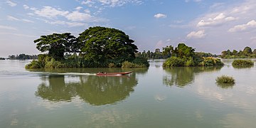 Pirogue and tiny wooded island reflecting in the water