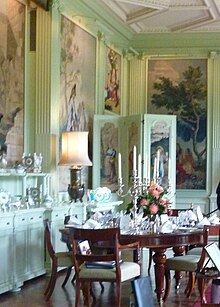 green-painted, panelled dining room with table set for dinner