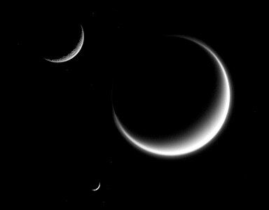 Titan (largest) together with Rhea and Mimas (smallest) in crescent shape, forming a triple crescent.[216] Titan's massive atmosphere is clearly seen extending out into space, while Rhea and Mimas have none.