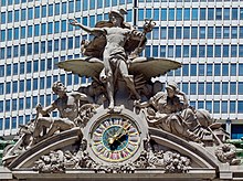 A large clock and stone sculptural group adorning the building's facade