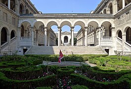 Petit jardin à la française entouré de galeries ouvertes à arcades, devant la cour intérieure.