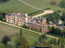 aerial view of large red-brick house in landscape