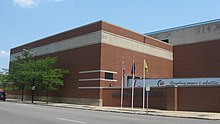 A picture of the back of the main office building for the South Bend Tribune. A semi truck can be seen in a loading station behind a wall. There is a large building attached that houses the printing press.