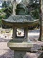 Stone lantern leading up to Kasuga Shrine framing a Nara Park deer, Nara