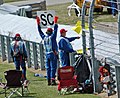 Flagsmen with a yellow flag and safety car sign
