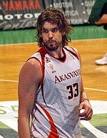 A basketball player, wearing a white jersey with the word «AKASVAYU» and the number 33 on the front, stands on a basketball court.