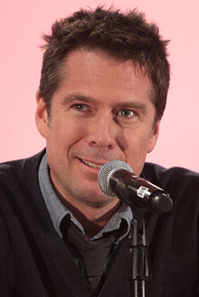 Alexis Denisof interprète Sandy Rivers.