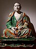 seated Buddhist monk in coloured pottery