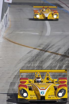 Picture of bright yellow RS Spyder racing car on a race track with another yellow car in the background