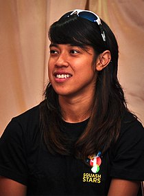 A woman in a black T-shirt and a sunglasses on her head, smiling