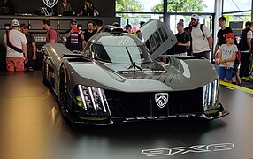 Photo de l'avant d'une voiture de course grise et noire sur un stand d'exposition.