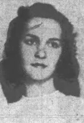 A young white woman with dark hair, wearing a white dress with a high neckline