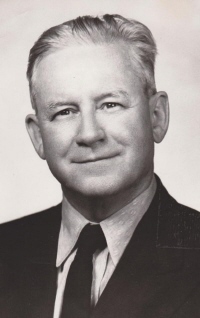 Headshot photo of Tommy Lockart wearing a suit and tie