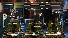 Green Day: Rock Band features gameplay similar to other games in the Rock Band series, played by avatars of the Green Day band members at recreations of venues from their concert tours. This screenshot shows "Are We the Waiting/St. Jimmy". Greenday keynes gameplay.jpg