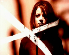 The music video's distinctive look was inspired by the title sequence of Seven (1995), and was achieved by director Samuel Bayer cutting, soaking and scratching the film negative. GarbageStupidGirlvideo1.png