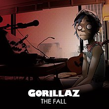 2-D of Gorillaz sits in a darkened room, turning his head to stare blankly at the viewer.