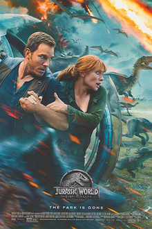 A man and a woman take cover behind a spherical vehicle, while various dinosaurs run from an erupting volcano.