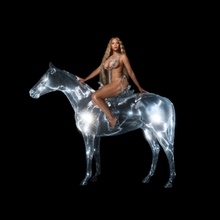 A black woman in a spiky metal bathing suit sits a top a crystal horse