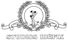 Emblème titré « Studios Idéfix », montrant un petit chien entouré d'un décor de rubans et couronnes de lauriers/chêne.