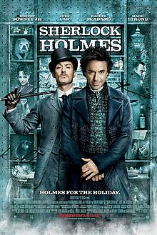 Robert Downey, Jr. and Jude Law, in-character. The background is a window display, featuring shelves containing miscellaneous objects relating to the story. The poster reads "Sherlock Holmes" across the top, with the tagline "Holmes for the holiday" centered at the bottom. The poster is predominately turquoise coloured.