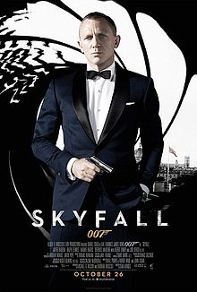 The poster shows a man wearing a tuxedo and holding a gun, standing in front of an image that looks like it was taken from the inside of a gun barrel, with the London skyline visible behind him. Text at the bottom of the poster reveals the film title and credits.