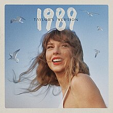 Bìa đĩa của 1989 (Taylor's Version) mô tả Swift và đàn hải âu phía nền, số "1989" màu trắng và biểu trưng "Taylor's Version" màu đen nhỏ hơn ở phía trên.