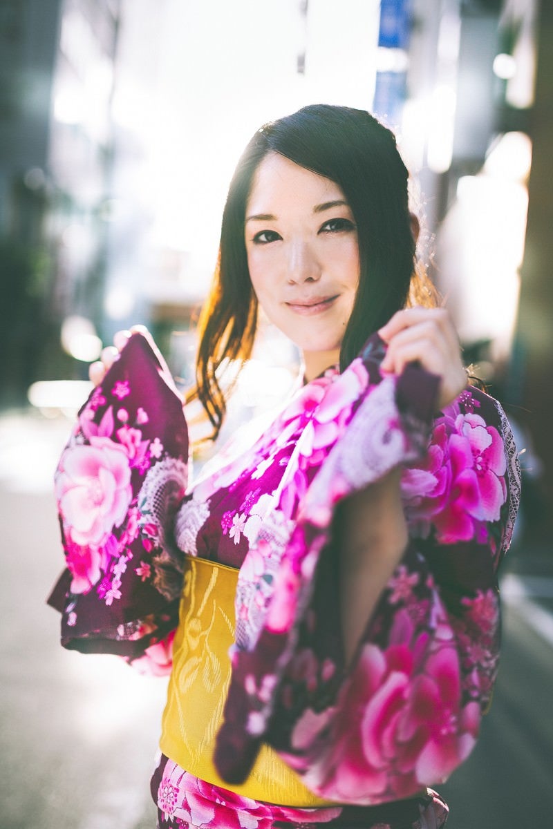 浴衣を見せて微笑む女性の写真