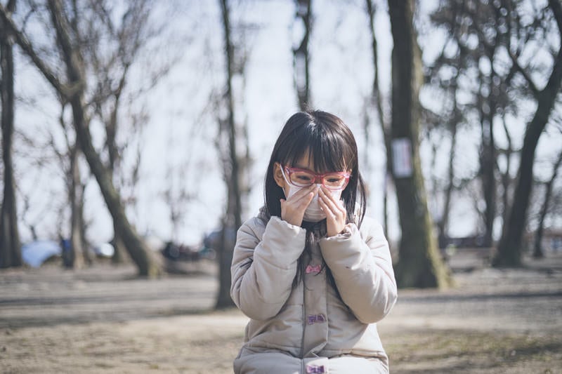 花粉症で目と鼻がつらい小学生の女の子の写真