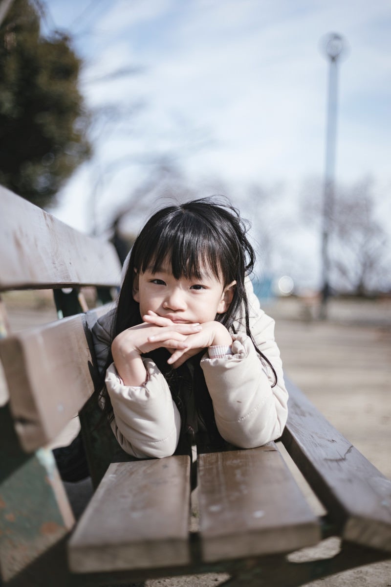 公園のベンチで愛娘のポートレートの写真