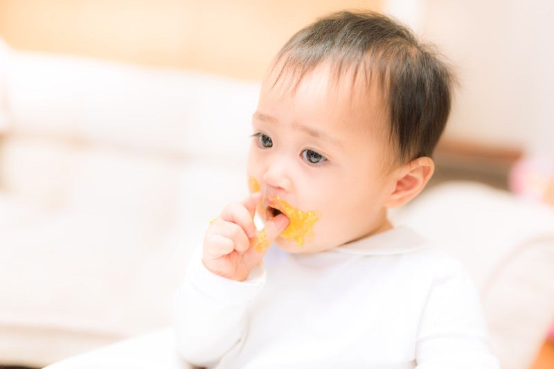 離乳食が口の周りにべっとり付いた赤ちゃんの写真