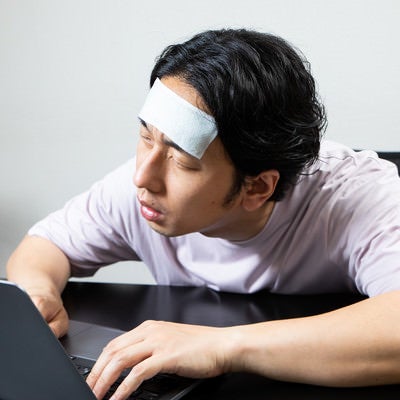 具合が悪くてデスクで居眠り男子の写真