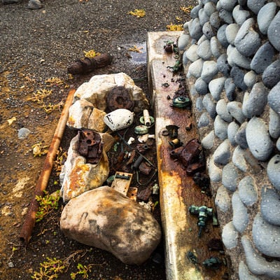 西大佐の碑に周辺から集められた旧軍装備品の残骸の写真