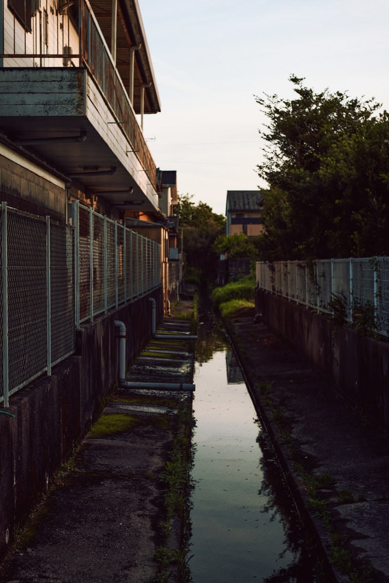 住宅街の横を通る用水路の写真