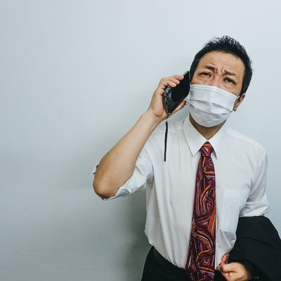 暑さで朦朧としながら会社に報告の電話をいれる外回りの写真