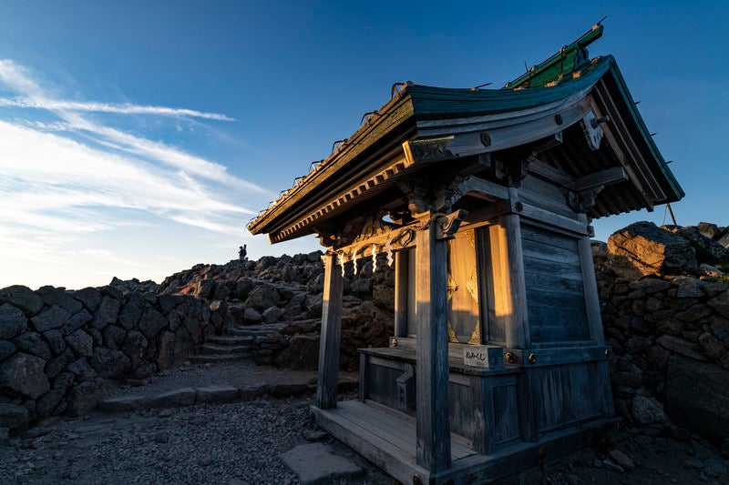 夕日に染まる御前峰の奥社（白山）の写真