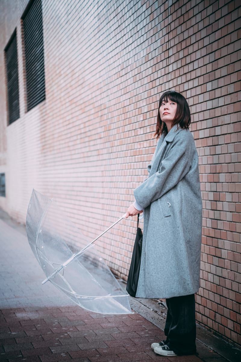 雨宿りする女性の写真