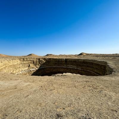 広大な砂漠地帯にあいた巨大なクレーターの写真